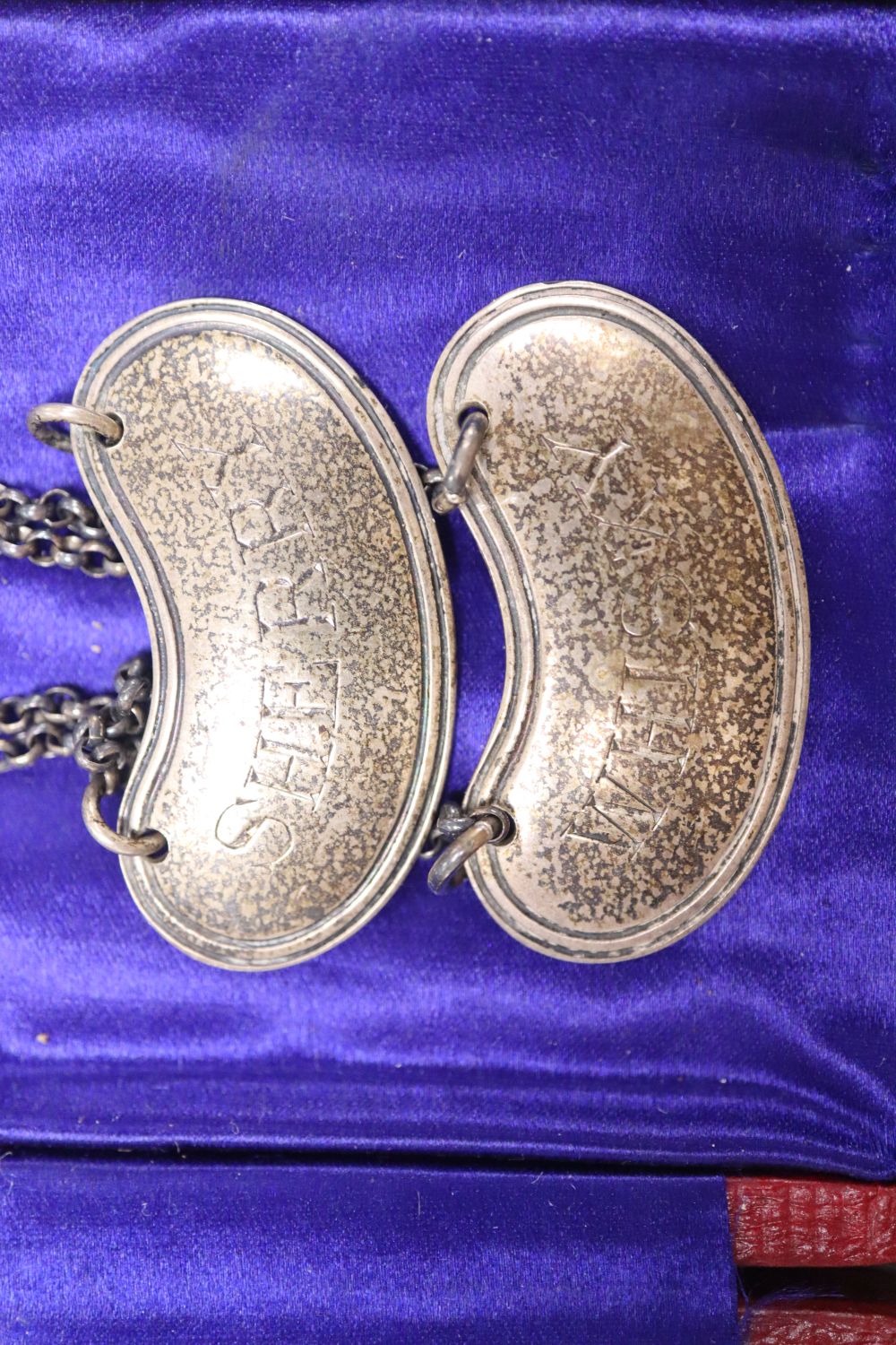 A pair of George V silver wine labels and cased Edwardian silver christening pair.